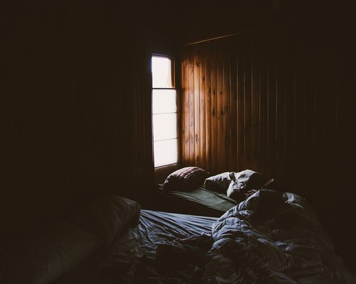 A quiet, dark bedroom prepared for night rest